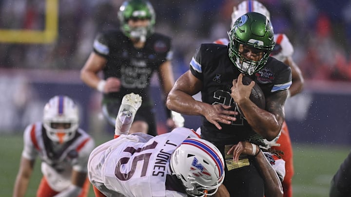 Dec 27, 2023; Annapolis, MD, USA;  Tulane Green Wave running back Makhi Hughes (21) rushes as Virginia Tech Hokies safety Jaylen Jones (15) attempts to tackle during the third quarter at Navy-Marine Corps Memorial Stadium. Mandatory Credit: Tommy Gilligan-Imagn Images