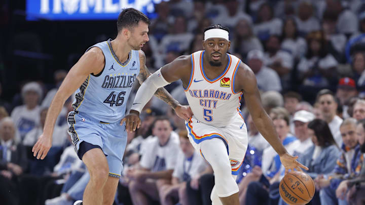 Apr 20, 2025; Oklahoma City, Oklahoma, USA; Oklahoma City Thunder guard Luguentz Dort (5) dribbles the ball down the court beside Memphis Grizzlies guard John Konchar (46) during the second quarter at Paycom Center. Mandatory Credit: Alonzo Adams-Imagn Images