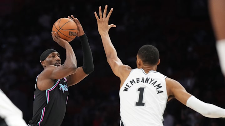 Mar 23, 2026; Miami, Florida, USA;  Miami Heat center Bam Adebayo (13) takes a shot over San Antonio Spurs forward Victor Wembanyama (1) during the first half at Kaseya Center. Mandatory Credit: Jim Rassol-Imagn Images