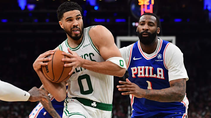 Apr 19, 2026; Boston, Massachusetts, USA; Boston Celtics forward Jayson Tatum (0) drives to the basket between Philadelphia 76ers forward Paul George (8) and center Andre Drummond (1) in the second half during game one of the first round of the 2026 NBA Playoffs at TD Garden. Mandatory Credit: Bob DeChiara-Imagn Images