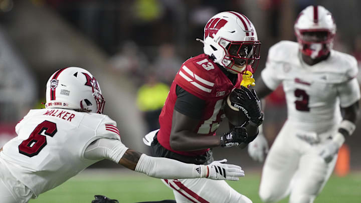 Aug 28, 2025; Madison, Wisconsin, USA;  Wisconsin Badgers wide receiver Eugene Hilton Jr. (13) runs with the football against Miami (OH) RedHawks defensive back Adrian Walker Jr. (6) during the third quarter at Camp Randall Stadium.
