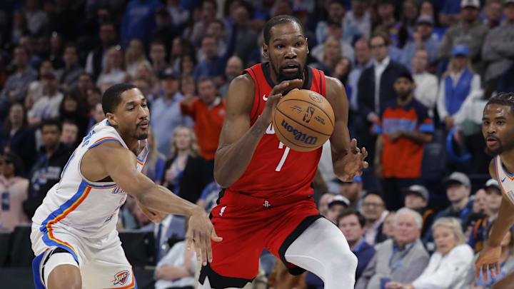 Feb 7, 2026; Oklahoma City, Oklahoma, USA; Houston Rockets forward Kevin Durant (7) drives between Oklahoma City Thunder guard Aaron Wiggins (21) and  guard Cason Wallace (22) during the second half at Paycom Center. Mandatory Credit: Alonzo Adams-Imagn Images