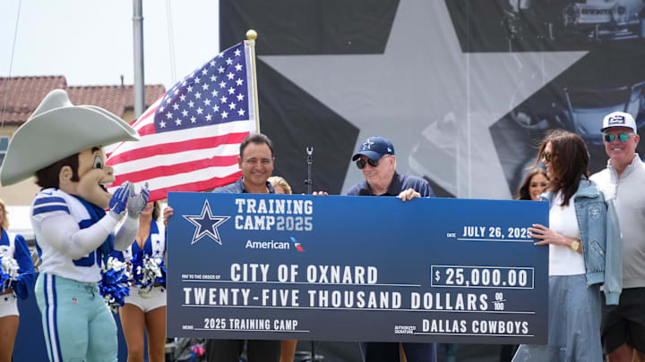 Dallas Cowboys owner Jerry Jones presents Oxnard mayor Luis McArthur with a $25,000 check at training camp opening ceremonies in Oxnard. 
