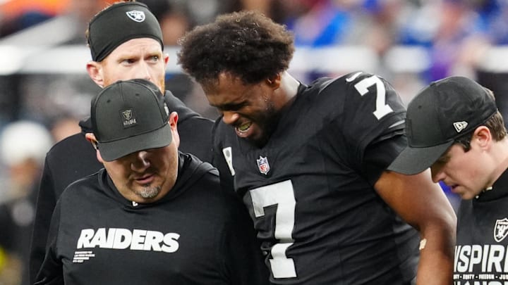 Dec 28, 2025; Paradise, Nevada, USA; Las Vegas Raiders quarterback Geno Smith (7) is helped off the field in the fourth quarter against the New York Giants at Allegiant Stadium. Mandatory Credit: Stephen R. Sylvanie-Imagn Images