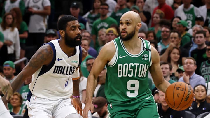 Jun 17, 2024; Boston, Massachusetts, USA; Boston Celtics guard Derrick White (9) dribbles the ball against Dallas Mavericks guard Kyrie Irving (11) and center Dereck Lively II (2) during the fourth quarter in game five of the 2024 NBA Finals at TD Garden. Mandatory Credit: Peter Casey-Imagn Images