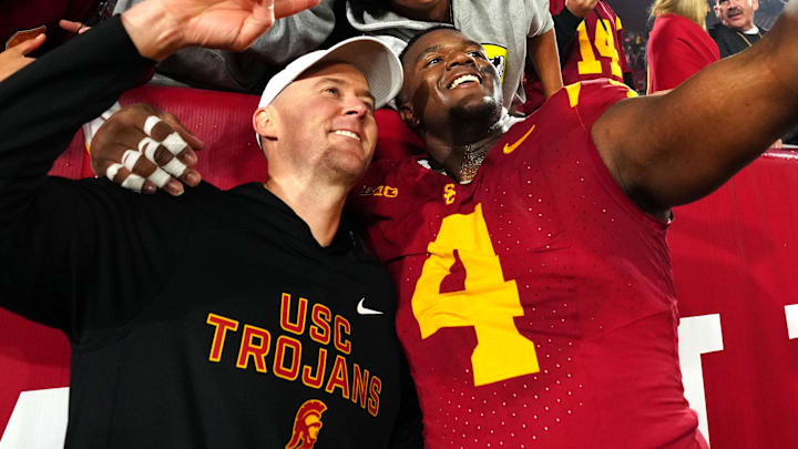 Nov 29, 2025; Los Angeles, California, USA; Southern California Trojans head coach Lincoln Riley (right) and defensive tackle Jahkeem Stewart (4) pose with fans after the game against the UCLA Bruins at United Airlines Field at Los Angeles Memorial Coliseum. Mandatory Credit: Kirby Lee-Imagn Images