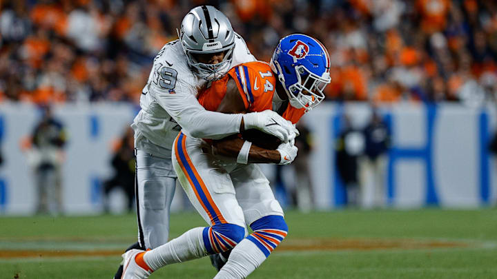 Nov 6, 2025; Denver, Colorado, USA; Denver Broncos wide receiver Courtland Sutton (14) is tackled by Las Vegas Raiders defensive end Charles Snowden (49) in the fourth quarter at Empower Field at Mile High. 