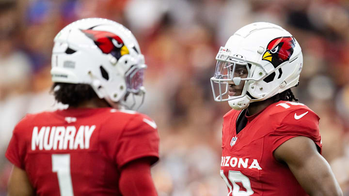 Sep 29, 2024; Glendale, Arizona, USA; Arizona Cardinals wide receiver Marvin Harrison Jr. (18) reacts alongside quarterback Kyler Murray (1) against the Washington Commanders in the first half at State Farm Stadium. Mandatory Credit: Mark J. Rebilas-Imagn Images Sep 29, 2024; Glendale, Arizona, USA; Arizona Cardinals wide receiver Marvin Harrison Jr. (18) reacts alongside quarterback Kyler Murray (1) against the Washington Commanders in the first half at State Farm Stadium. Mandatory Credit: Mark J. Rebilas-Imagn Images