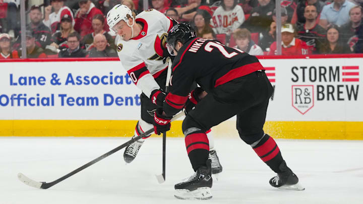 Apr 20, 2026; Raleigh, North Carolina, USA; Carolina Hurricanes defenseman Alexander Nikishin (21) blocks the shot by Ottawa Senators left wing Fabian Zetterlund (20) during the first overtime in game two of the first round of the 2026 Stanley Cup Playoffs at Lenovo Center. Mandatory Credit: James Guillory-Imagn Images