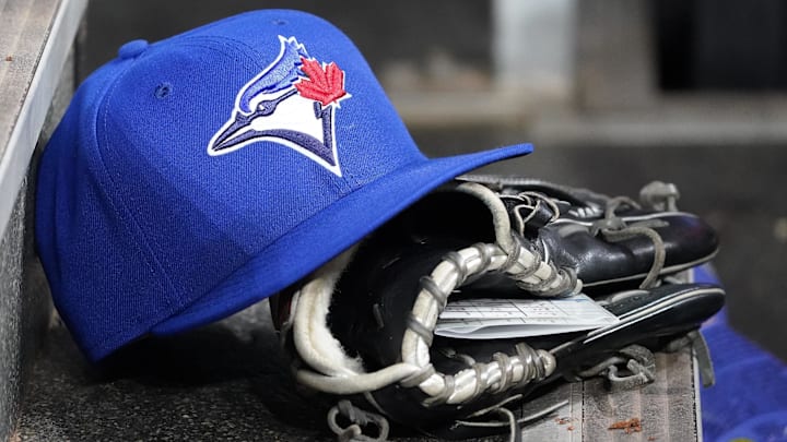 Apr 16, 2025; Toronto, Ontario, CAN; A Toronto Blue Jays hat and glove in the dugout during a game against the Atlanta Braves at Rogers Centre. 
