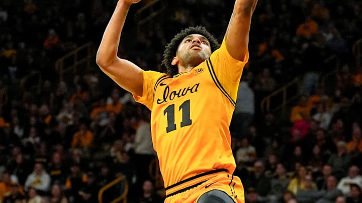 Iowa guard Kael Combs (11) shoots a transition layup as Northwestern forward Nick Martinelli (2) trails behind Feb. 8, 2026 at Carver-Hawkeye Arena in Iowa City, Iowa.