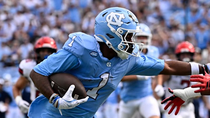 Sep 13, 2025; Chapel Hill, North Carolina, USA; North Carolina Tar Heels wide receiver Jordan Shipp (1) scores a touchdown as Richmond Spiders defensive back Lee Bruner IV (19) defends in the first quarter at Kenan Stadium. Mandatory Credit: Bob Donnan-Imagn Images