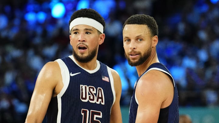 Aug 10, 2024; Paris, France; United States guard Devin Booker (15) and shooting guard Stephen Curry (4) react in the second half against France in the men's basketball gold medal game during the Paris 2024 Olympic Summer Games at Accor Arena. Mandatory Credit: Rob Schumacher-Imagn Images