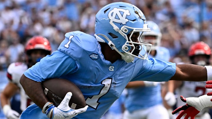 Sep 13, 2025; Chapel Hill, North Carolina, USA; North Carolina Tar Heels wide receiver Jordan Shipp (1) scores a touchdown as Richmond Spiders defensive back Lee Bruner IV (19) defends in the first quarter at Kenan Stadium. Mandatory Credit: Bob Donnan-Imagn Images