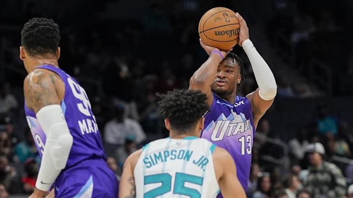 Mar 31, 2025; Charlotte, North Carolina, USA; Utah Jazz guard Isaiah Collier (13) shoots a three defended by Charlotte Hornets guard KJ Simpson (25) during the second half at Spectrum Center. Mandatory Credit: Jim Dedmon-Imagn Images