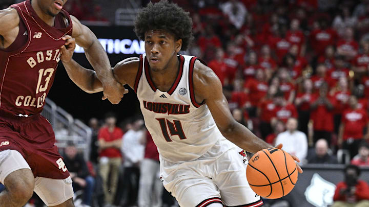 Jan 10, 2026; Louisville, Kentucky, USA;  Louisville Cardinals guard Adrian Wooley (14) dribbles against Boston College Eagles guard Donald Hand Jr. (13) during the second half at KFC Yum! Center.  Mandatory Credit: Jamie Rhodes-Imagn Images