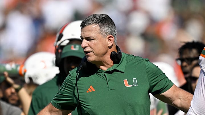 Nov 1, 2025; Dallas, Texas, USA;  Miami Hurricanes head coach Mario Cristobal talks to offensive lineman Anez Cooper (73) and offensive lineman Francis Mauigoa (61) during the second half against the SMU Mustangs at Gerald J. Ford Stadium. Mandatory Credit: Jerome Miron-Imagn Images