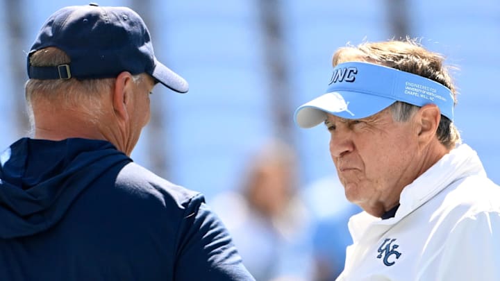 Sep 13, 2025; Chapel Hill, North Carolina, USA; Richmond Spiders head coach Russ Huesman talks to North Carolina Tar Heels general manger Michael Lombardi and head coach Bill Belichick before the game at Kenan Stadium. Mandatory Credit: Bob Donnan-Imagn Images Sep 13, 2025; Chapel Hill, North Carolina, USA; Richmond Spiders head coach Russ Huesman talks to North Carolina Tar Heels general manger Michael Lombardi and head coach Bill Belichick before the game at Kenan Stadium. Mandatory Credit: Bob Donnan-Imagn Images