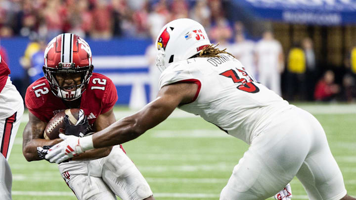 Sep 16, 2023; Indianapolis, Indiana, USA; Indiana Hoosiers running back Jaylin Lucas (12) runs the ball against Louisville Cardinals linebacker TJ Quinn (34) in the second half at Lucas Oil Stadium. Mandatory Credit: Trevor Ruszkowski-Imagn Images