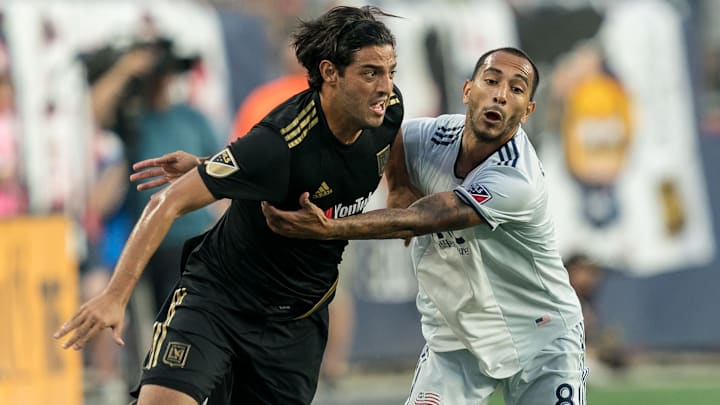 El mexicano Carlos Vela de LAFC y Edgar Castillo del New England Revolution compiten por la pelota en la temporada 2019.