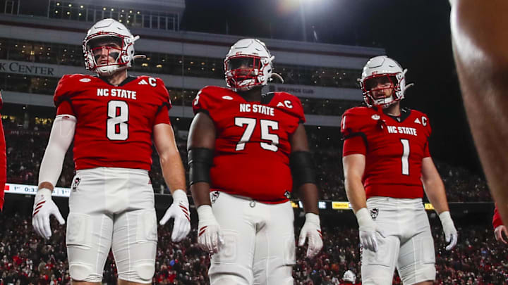 Nov 29, 2025; Raleigh, North Carolina, USA;  NC State Wolfpack wide receiver Keenan Jackson (8), offensive lineman Jr. Anthony Carter (75), and linebacker Caden Fordham (1) at the coin toss before the first half of the game against North Carolina Tar Heels at Carter-Finley Stadium.  Mandatory Credit: Jaylynn Nash-Imagn Images