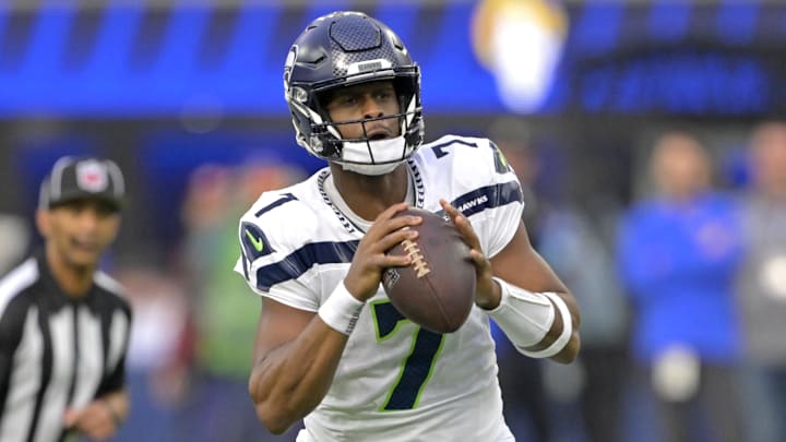 Jan 5, 2025; Inglewood, California, USA; Seattle Seahawks quarterback Geno Smith (7) scrambles away from Los Angeles Rams linebacker Byron Young (0) and throws for a touchdown in the first half at SoFi Stadium. Mandatory Credit: Jayne Kamin-Oncea-Imagn Images