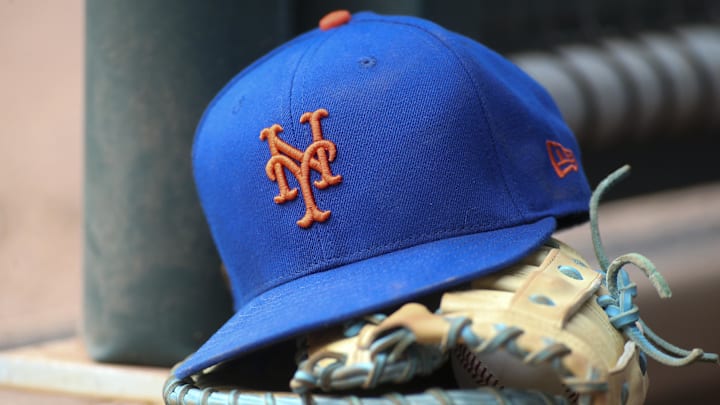 Jul 13, 2022; Atlanta, Georgia, USA; A detailed view of a New York Mets hat and glove in the dugout against the Atlanta Braves in the eighth inning at Truist Park. 