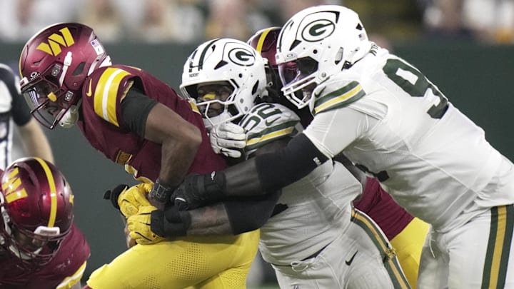 Sep 11, 2025; Green Bay, Wisconsin, USA; Washington Commanders quarterback Jayden Daniels (5) is sacked by Green Bay Packers defensive end Rashan Gary (52) and defensive tackle Devonte Wyatt (95) during the third quarter at Lambeau Field.