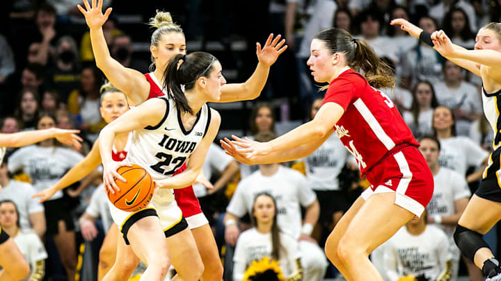 Iowa guard Caitlin Clark (22) is defended by Nebraska guard Jaz Shelley, left, and Nebraska forward Isabelle Bourne during the 2022-23 season.