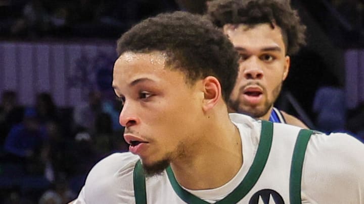 Milwaukee Bucks guard Ryan Rollins handles the ball in front of Orlando Magic guard Jalen Suggs.
