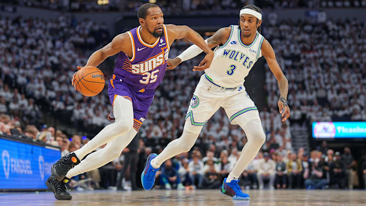 Apr 23, 2024; Minneapolis, Minnesota, USA; Phoenix Suns forward Kevin Durant (35) dribbles against Minnesota Timberwolves forward Jaden McDaniels (3) in the second quarter during game two of the first round for the 2024 NBA playoffs at Target Center.