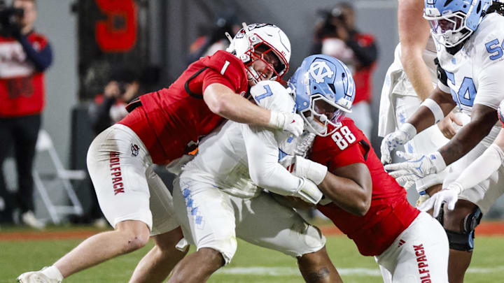 Nov 29, 2025; Raleigh, North Carolina, USA;  NC State Wolfpack linebacker Caden Fordham (1) and defensive end Isaiah Shirley (88) tackles North Carolina Tar Heels quarterback Gio Lopez (7) during the first half of the game against North Carolina Tar Heels at Carter-Finley Stadium.  Mandatory Credit: Jaylynn Nash-Imagn Images
