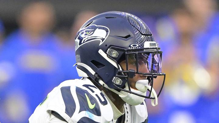 Seattle Seahawks quarterback Geno Smith hands off to running back Kenny McIntosh.