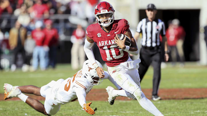 Arkansas quarterback Taylen Green (10) breaks containment against the Texas Longhorns defense as Jelani McDonald makes a last-ditch effort at Razorback Stadium Nov. 16. Texas beat the Hogs 20-10.