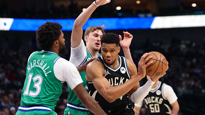 Nov 10, 2025; Dallas, Texas, USA; Milwaukee Bucks forward Giannis Antetokounmpo (34) controls the ball as Dallas Mavericks forward Cooper Flagg (32) and Dallas Mavericks forward Naji Marshall (13) defend during the first quarter at American Airlines Center. Mandatory Credit: Kevin Jairaj-Imagn Images
