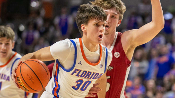 Florida guard Kajus Kublickas (30) drives past Arkansas guard Joseph Pinion (5) during the second half of an NCAA basketball game in Gainesville, FL on Saturday, January 13, 2024. [Alan Youngblood/Gainesville Sun]