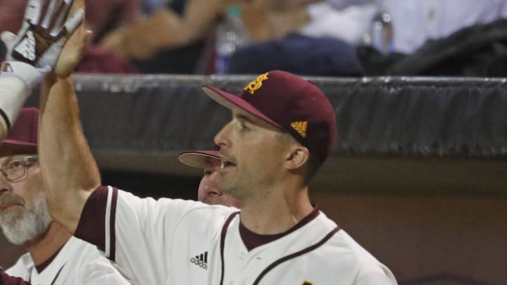 ASU's Gage Workman (14) high fives with head coach Tracy Smith (center) and hitting coach Michael Earley (R) after scoring during the first inning against Arizona at Phoenix Municipal Stadium in Phoenix, Ariz. on March 30, 2019