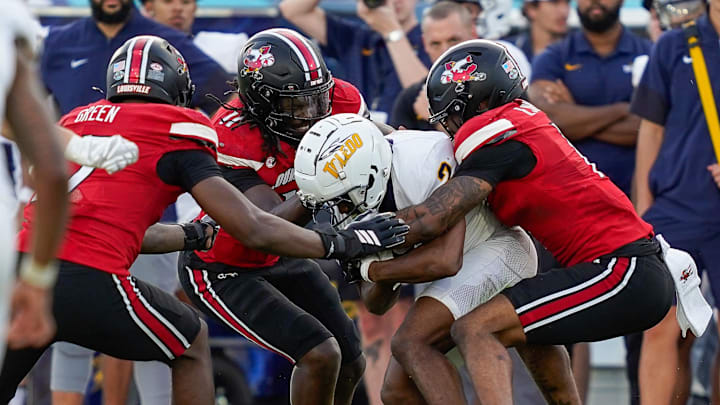 Dec 23, 2025; Boca Raton, FL, USA; Toledo Rockets wide receiver Junior Vandeross III (2) is tackled by the Louisville Cardinals defense during the third quarter of the Boca Raton Bowl at Flagler CU Stadium. Mandatory Credit: Jeff Romance-Imagn Images