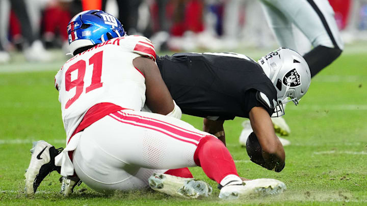 Dec 28, 2025; Paradise, Nevada, USA; Las Vegas Raiders quarterback Geno Smith (7) is sacked by New York Giants defensive lineman Darius Alexander (91) in the fourth quarter at Allegiant Stadium. Mandatory Credit: Stephen R. Sylvanie-Imagn Images