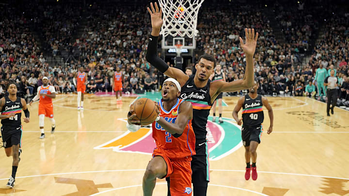 Dec 23, 2025; San Antonio, Texas, USA; Oklahoma City Thunder guard Shai Gilgeous-Alexander (2) drives to the basket past San Antonio Spurs forward Victor Wembanyama (1) during the first half at Frost Bank Center. Mandatory Credit: Scott Wachter-Imagn Images