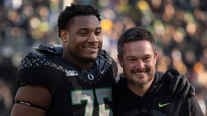 Oregon’s Isaiah World, left, takes a picture with coach Dan Lanning before the game against Southern California Nov. 22, 2025.