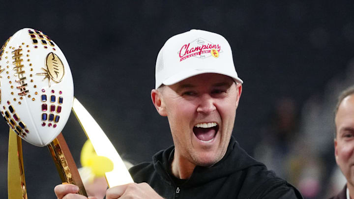 Dec 27, 2024; Las Vegas, NV, USA; Southern California Trojans head coach Lincoln Riley holds the championship trophy after the game against the Texas A&M Aggies at Allegiant Stadium. Dec 27, 2024; Las Vegas, NV, USA; Southern California Trojans head coach Lincoln Riley holds the championship trophy after the game against the Texas A&M Aggies at Allegiant Stadium.