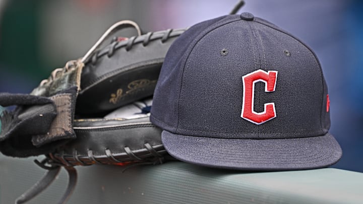 Jun 27, 2024; Kansas City, Missouri, USA; A general view a Cleveland Guardians hat and glove on the dugout railing  before a game against the Kansas City Royals at Kauffman Stadium. Mandatory Credit: Peter Aiken-Imagn Images
