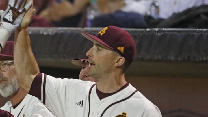 ASU's Gage Workman (14) high fives with head coach Tracy Smith (center) and hitting coach Michael Earley (R) after scoring during the first inning against Arizona at Phoenix Municipal Stadium in Phoenix, Ariz. on March 30, 2019