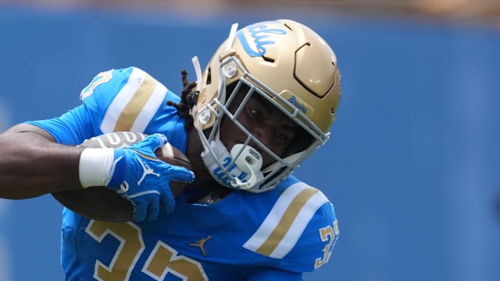 May 2, 2026; Pasadena, CA, USA; UCLA Bruins running back Karson Cox (33) is tackled by defensive back Logan Hirou (35)during the spring game at Rose Bowl. Mandatory Credit: Kirby Lee-Imagn Images