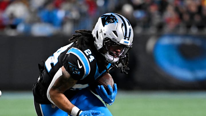 Dec 1, 2024; Charlotte, North Carolina, USA; Carolina Panthers running back Jonathon Brooks (24) runs as Tampa Bay Buccaneers cornerback Zyon McCollum (27) defends in the third quarter at Bank of America Stadium. Mandatory Credit: Bob Donnan-Imagn Images