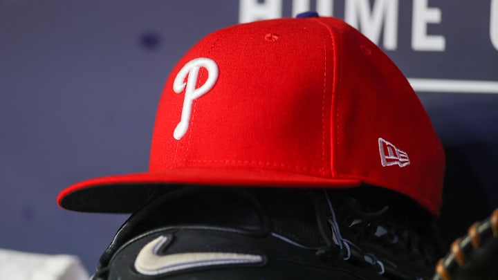 May 26, 2023; Atlanta, Georgia, USA; A detailed view of a Philadelphia Phillies hat and glove on the bench against the Atlanta Braves in the seventh inning at Truist Park. 