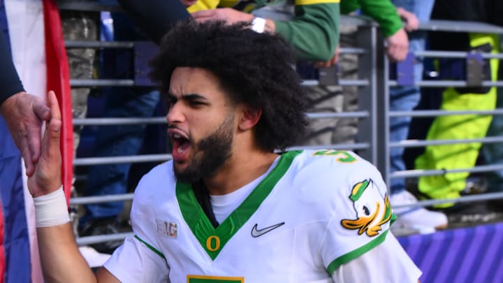 Nov 29, 2025; Seattle, Washington, USA; Oregon Ducks quarterback Dante Moore (5) celebrates with fans after Oregon defeated the Washington Huskies at Husky Stadium. Mandatory Credit: Steven Bisig-Imagn Images Nov 29, 2025; Seattle, Washington, USA; Oregon Ducks quarterback Dante Moore (5) celebrates with fans after Oregon defeated the Washington Huskies at Husky Stadium. Mandatory Credit: Steven Bisig-Imagn Images