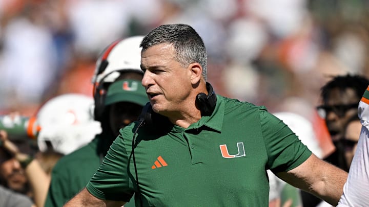 Nov 1, 2025; Dallas, Texas, USA;  Miami Hurricanes head coach Mario Cristobal talks to offensive lineman Anez Cooper (73) and offensive lineman Francis Mauigoa (61) during the second half against the SMU Mustangs at Gerald J. Ford Stadium. Mandatory Credit: Jerome Miron-Imagn Images
