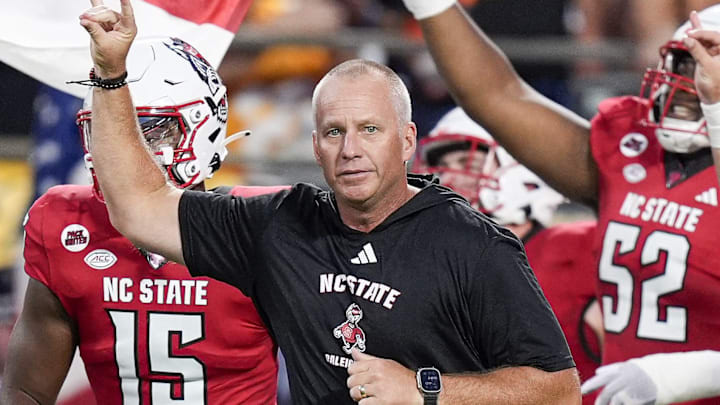 Sep 7, 2024; Charlotte, North Carolina, USA; North Carolina State Wolfpack head coach Dave Doeren leads his team onto the field against the Tennessee Volunteers during the first quarter at the Dukes Mayo Classic at Bank of America Stadium. Mandatory Credit: Jim Dedmon-Imagn Images